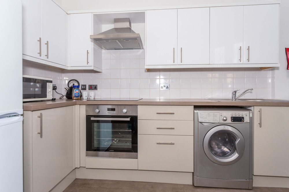 Kitchen area with induction hob and cookers, washer/dryer,. fridge freezer, sink and microwave