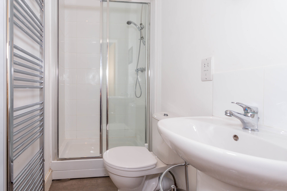 En-suite bathroom with shower and towel rack radiator