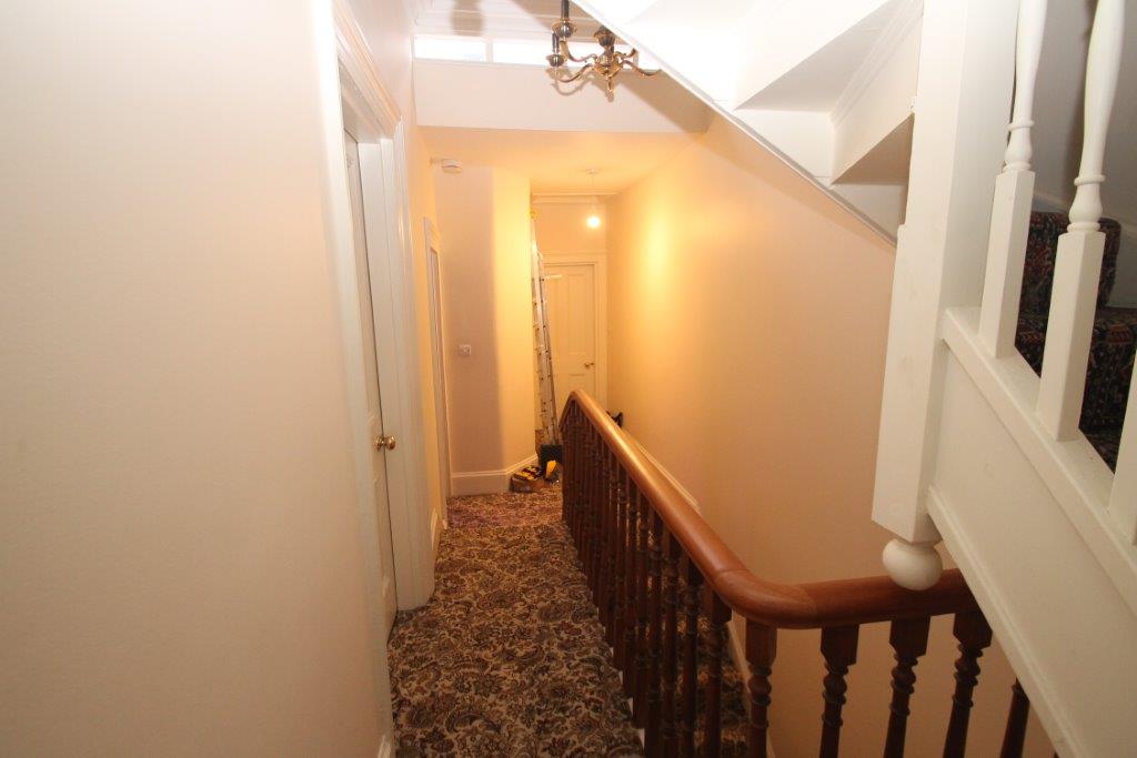 First floor landing showing entrances to rooms and another staircase going up