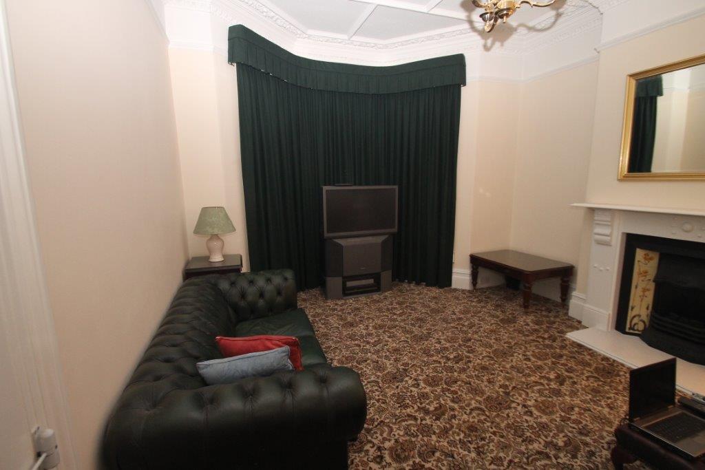 Shared living room with two seater sofa, three seater sofa, tv and large bay windows