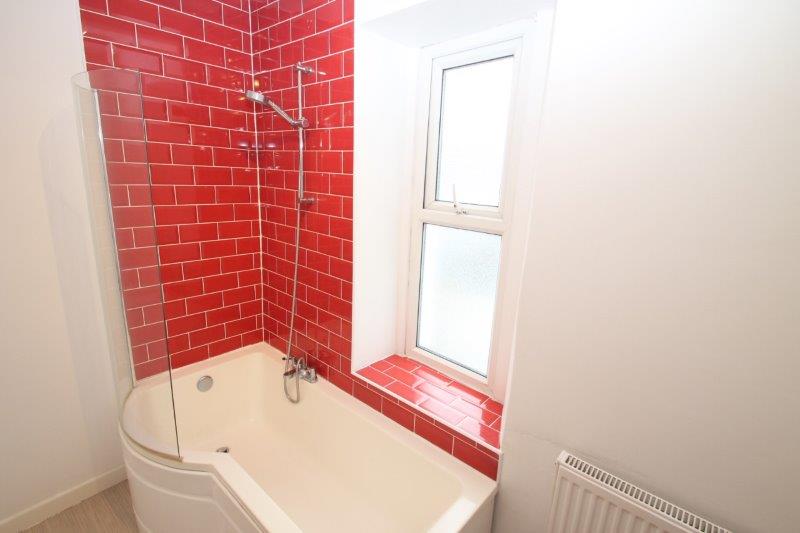 red tiled bathroom with shower head