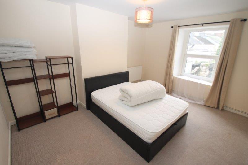 student bedroom with double bed and clothing rails