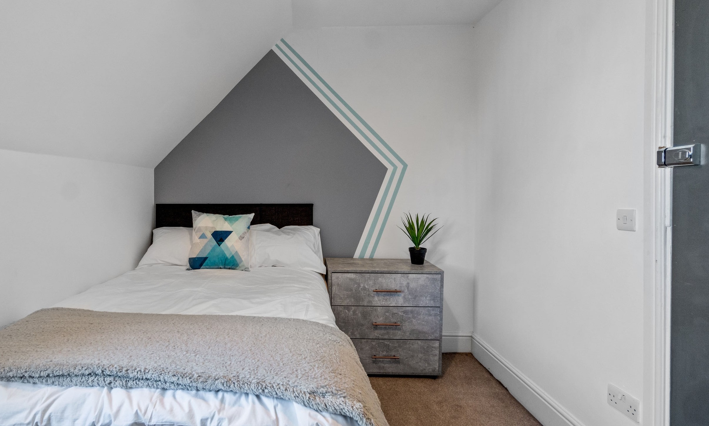 student bedroom with double bed and chest of drawers