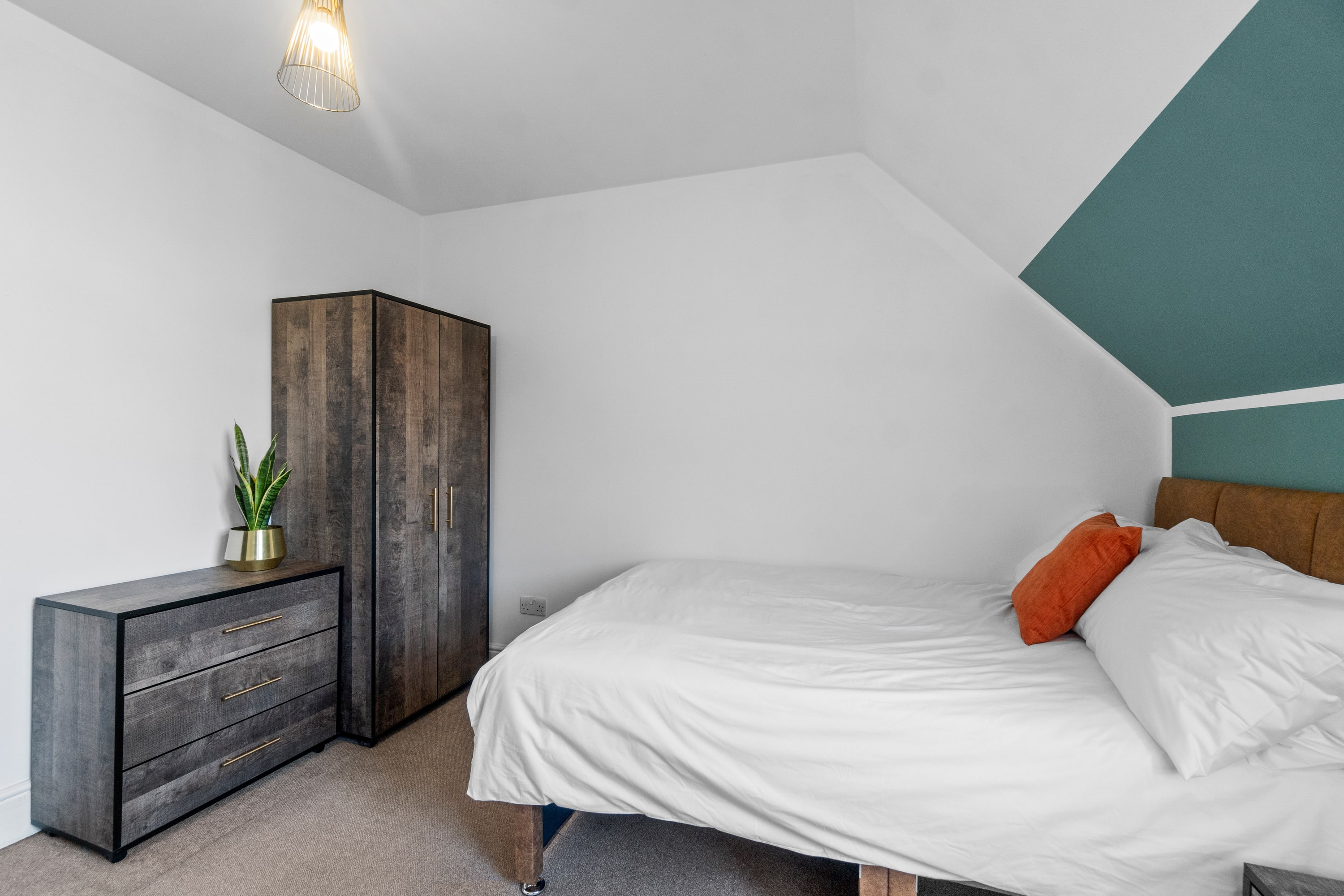 student bedroom with double bed, two door wardrobe, chest of drawers and bedside table