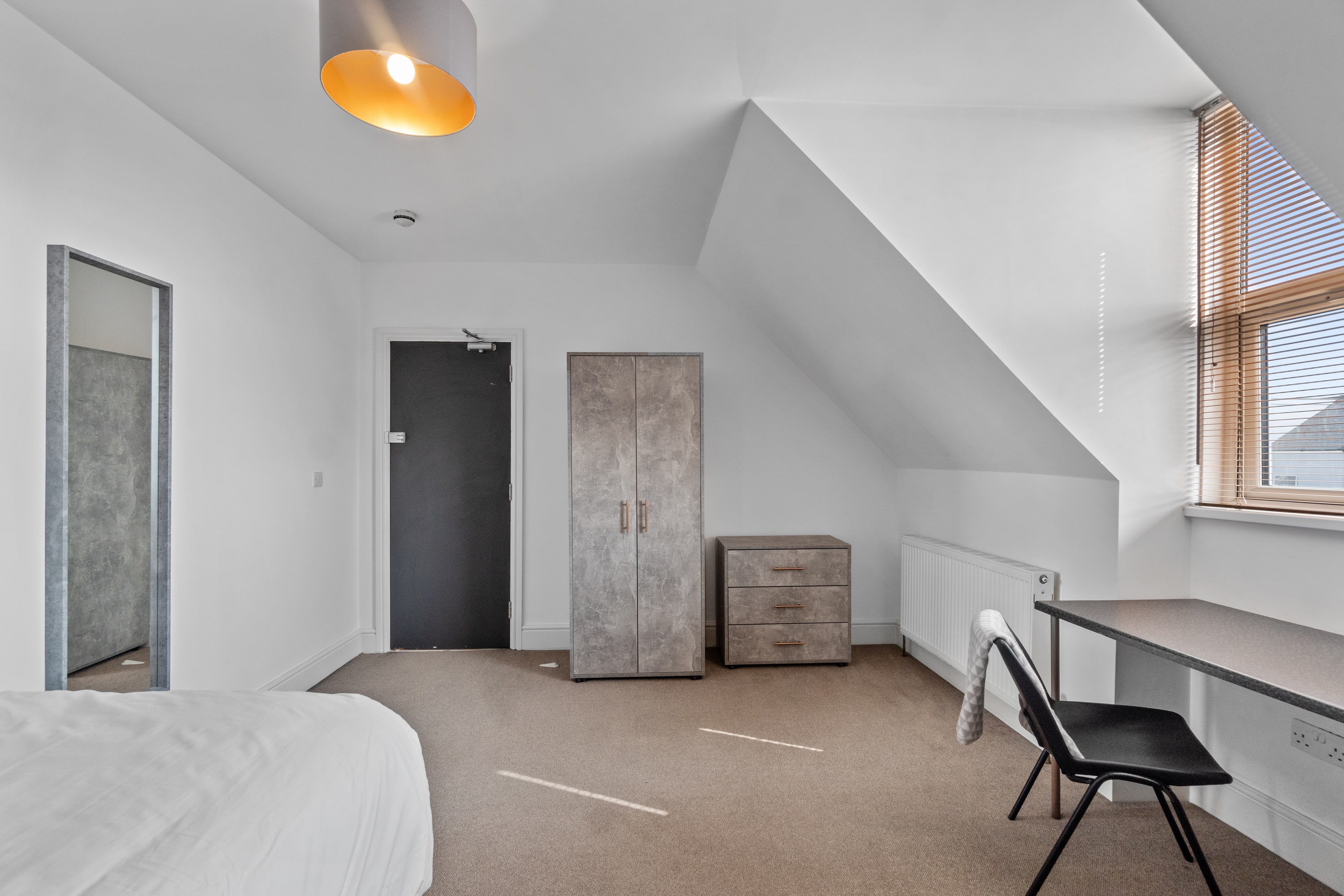 Student bedroom with double bed, two door wardrobe, chest of drawers, desk with chair and full length mirror