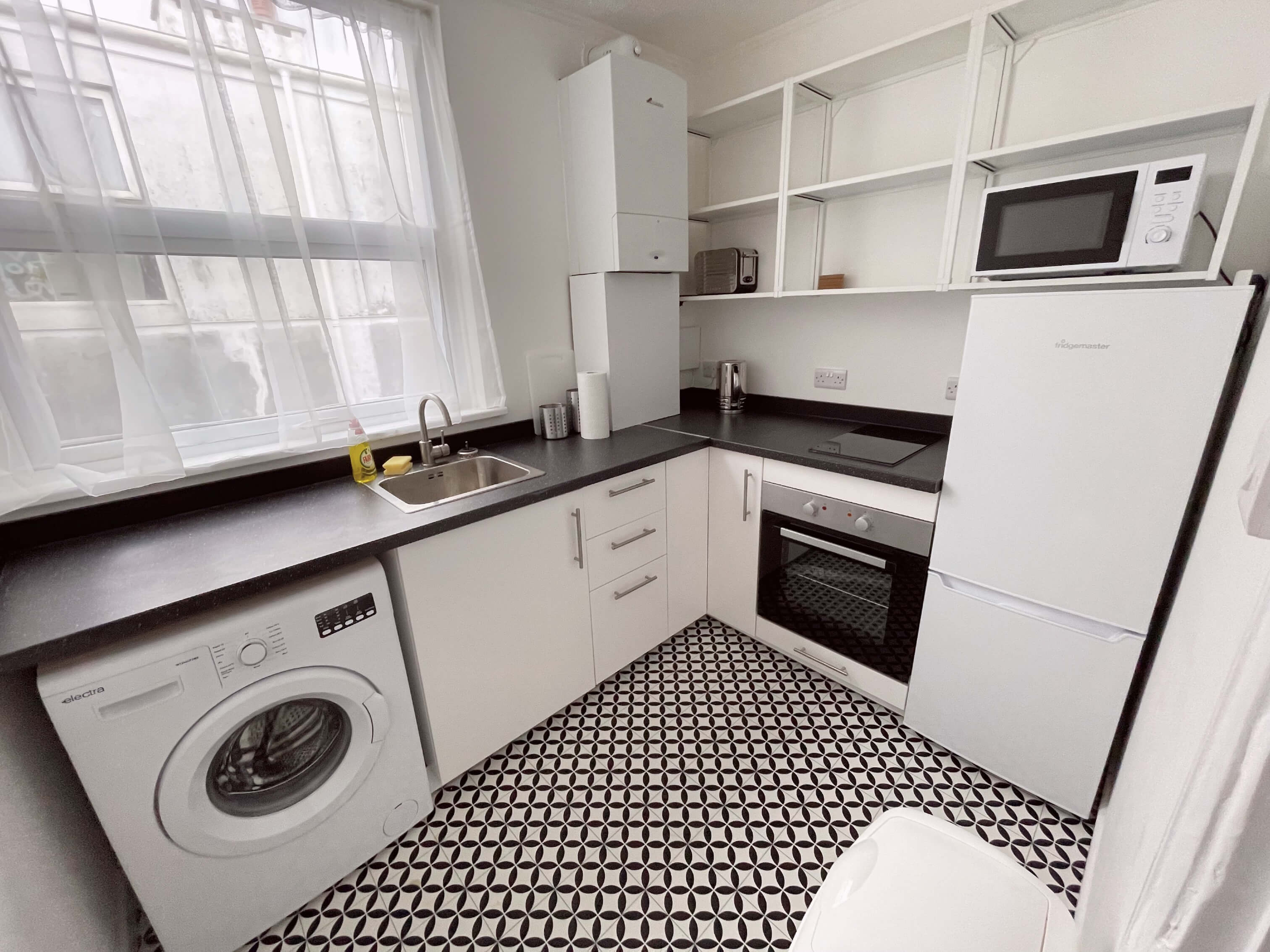 Kitchen with induction hob and cooker, washer/dryer and fridge freezer and sink