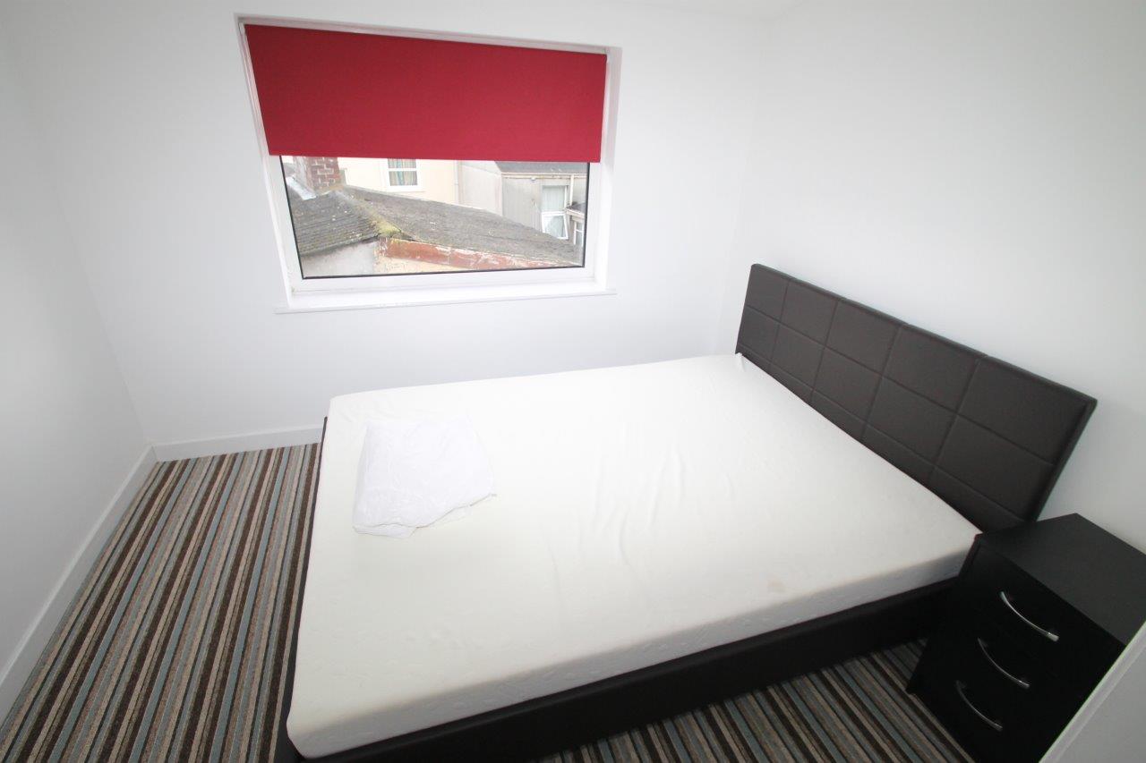 Student room with double bed and bedside drawer 