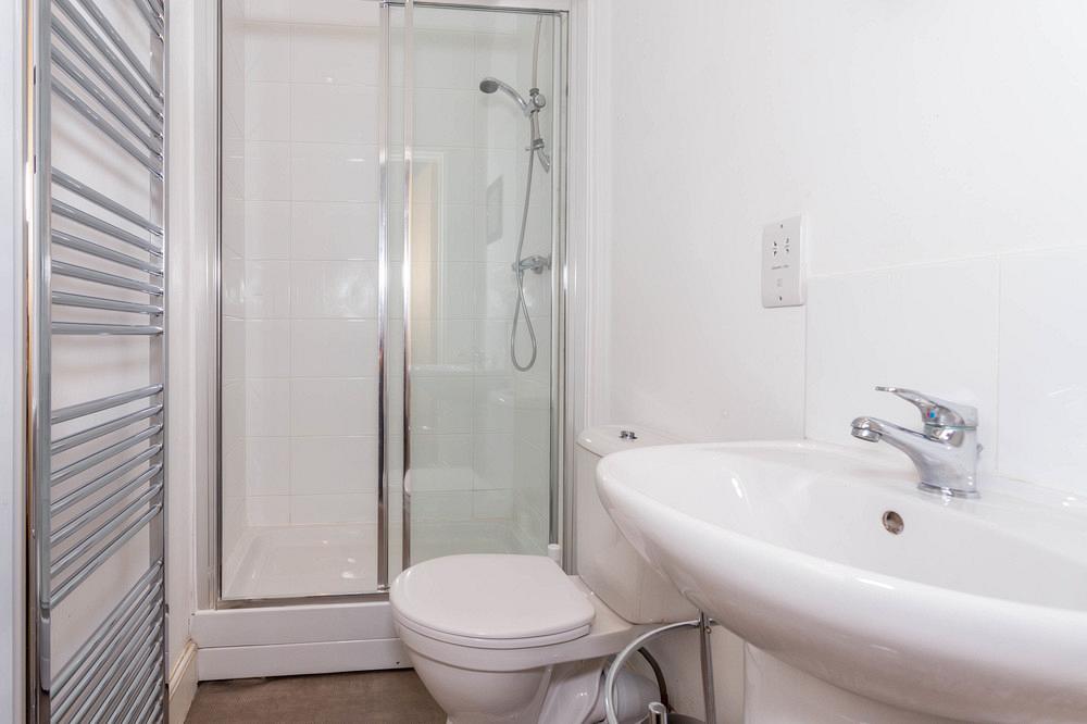 En-suite bathroom with shower and towel rack radiator