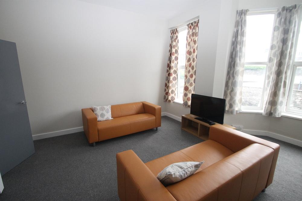 living area with two yellow sofas and television on tv stand