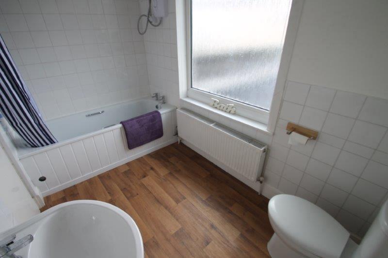 shared bathroom with bath with shower head