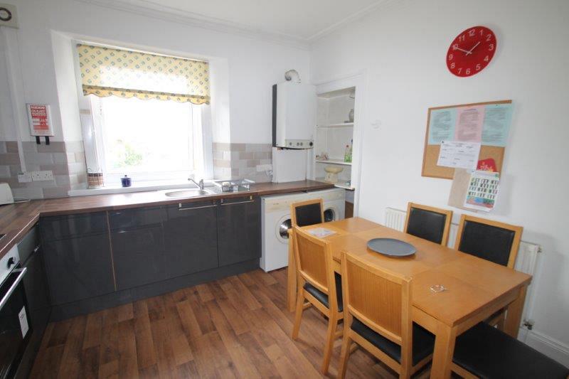 kitchen with washing machine, tumble dryer and dining table with six dining chairs