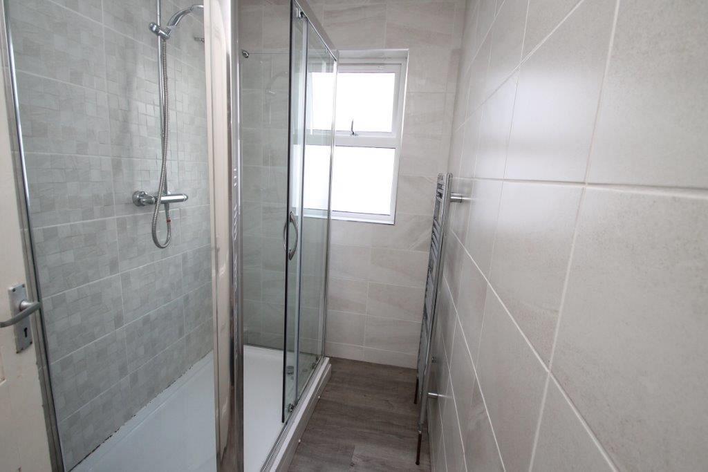 shared bathroom with large shower and towel rack radiator 
