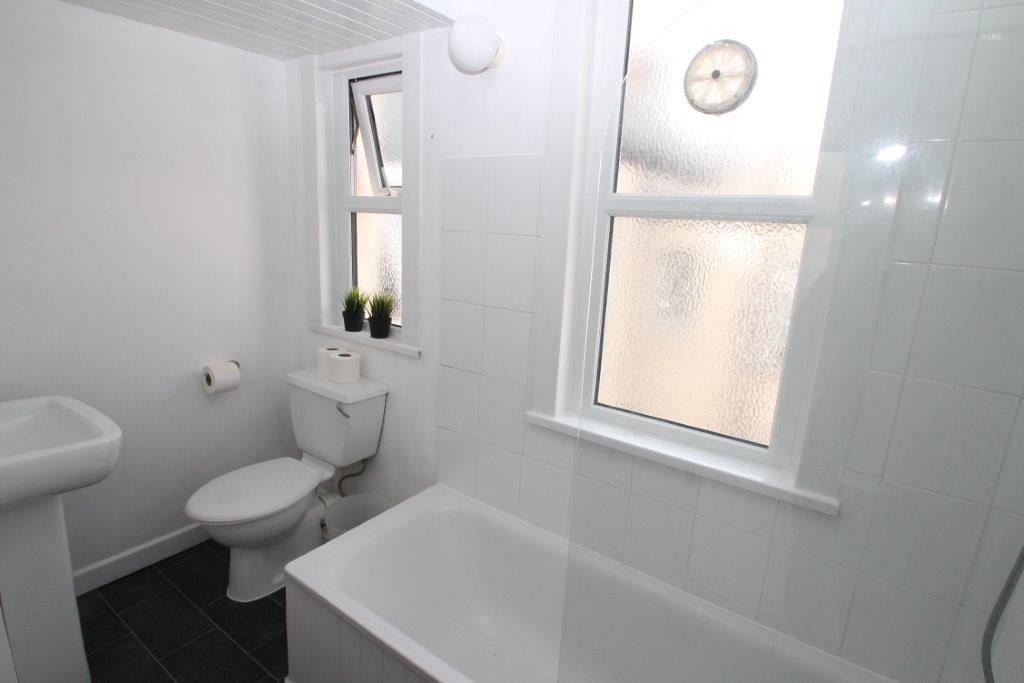 Shared bathroom with bath with shower head 