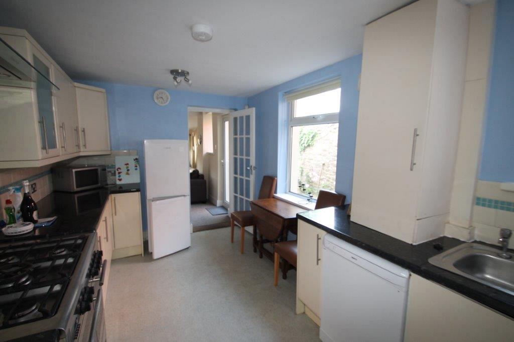 shared kitchen with fridge freezer, large gas hob and cooker, dishwasher and collapsible dining table with two dining chairs