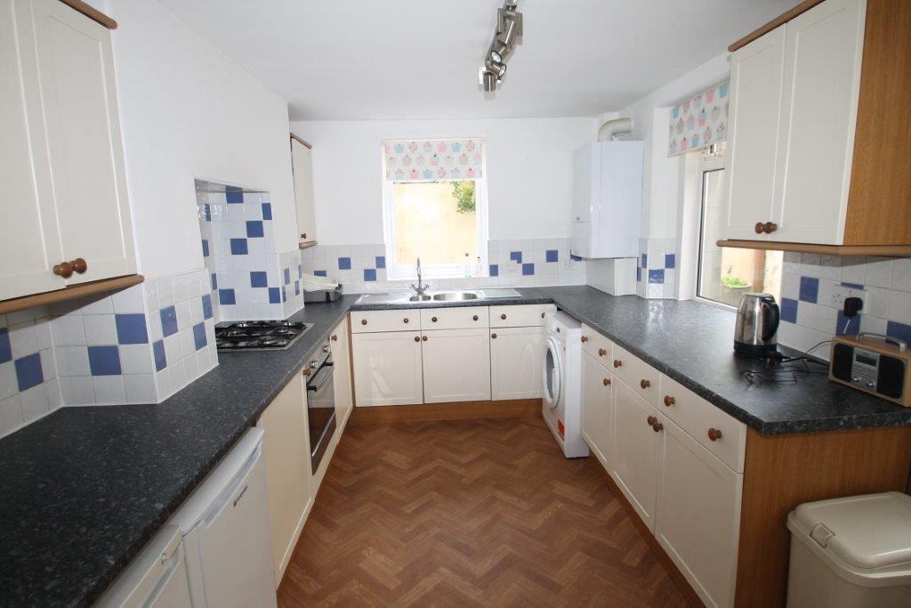 shared kitchen with washing machine, gas hobs and cooker, small fridge and freezer
