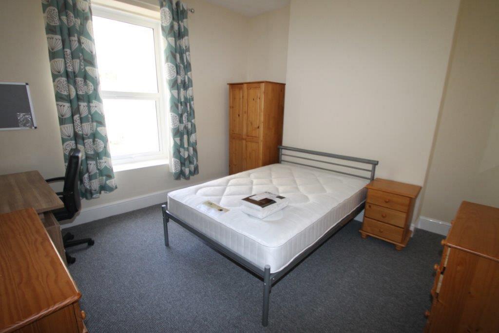 Third student bedroom with double bed, two chest of drawers, two door wardrobe, bedside table and desk with black office chair