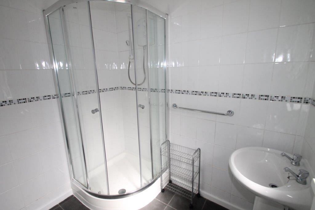 Shared bathroom with corner shower, sink and towel rail
