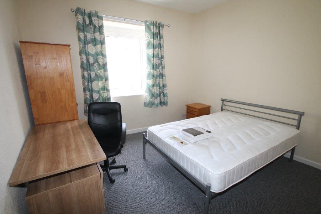 First student bedroom with double bed, chest of drawers, desk with drawers and two door wardrobe 