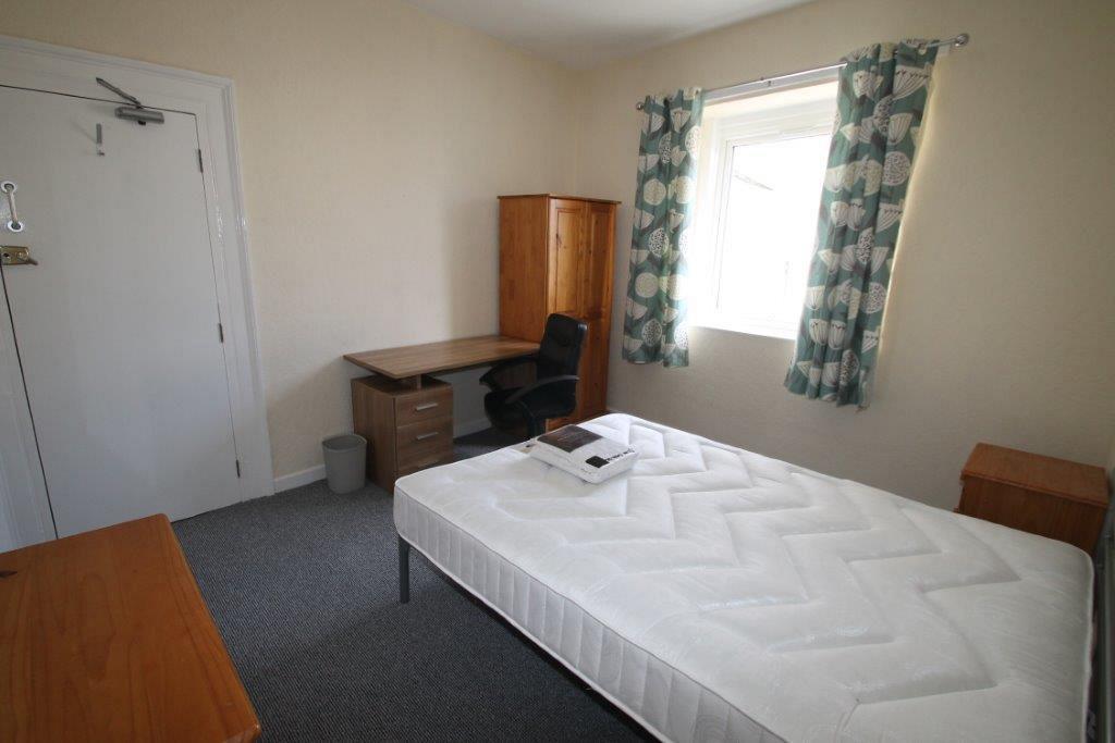 First student bedroom with double bed, bedside table, chest of drawers, desk with drawers and two door wardrobe