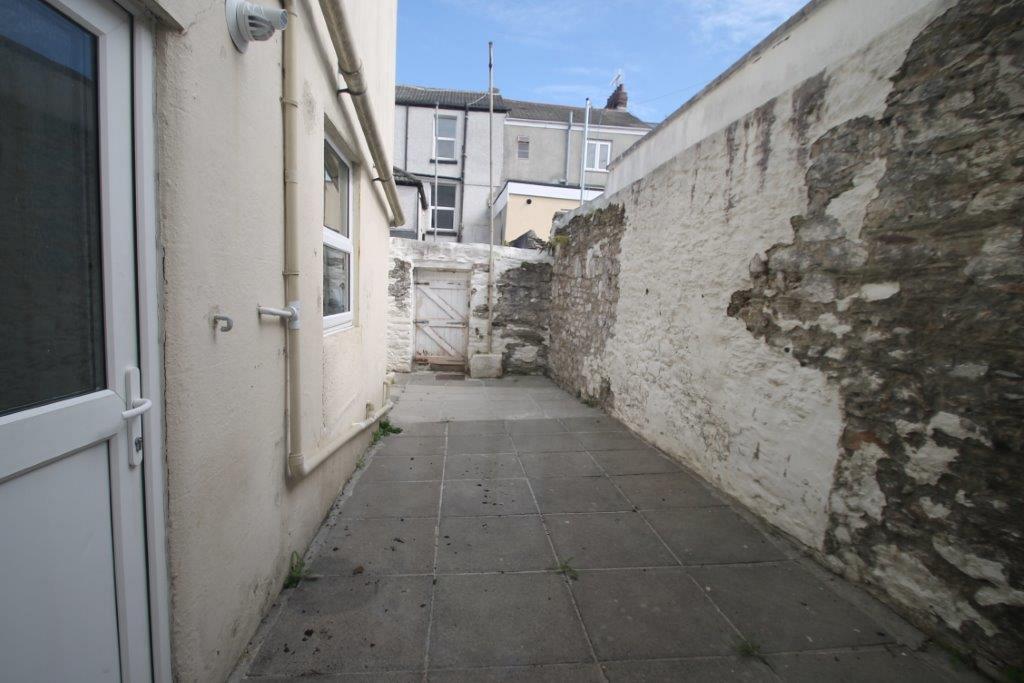 Shared back patio leading to back gate for the back alley of property