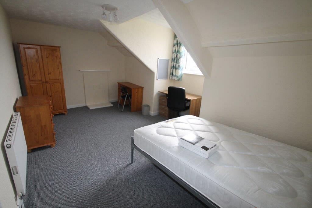 Second student bedroom with double bed, two wooden desks with chairs, chest of drawers and two door wardrobe