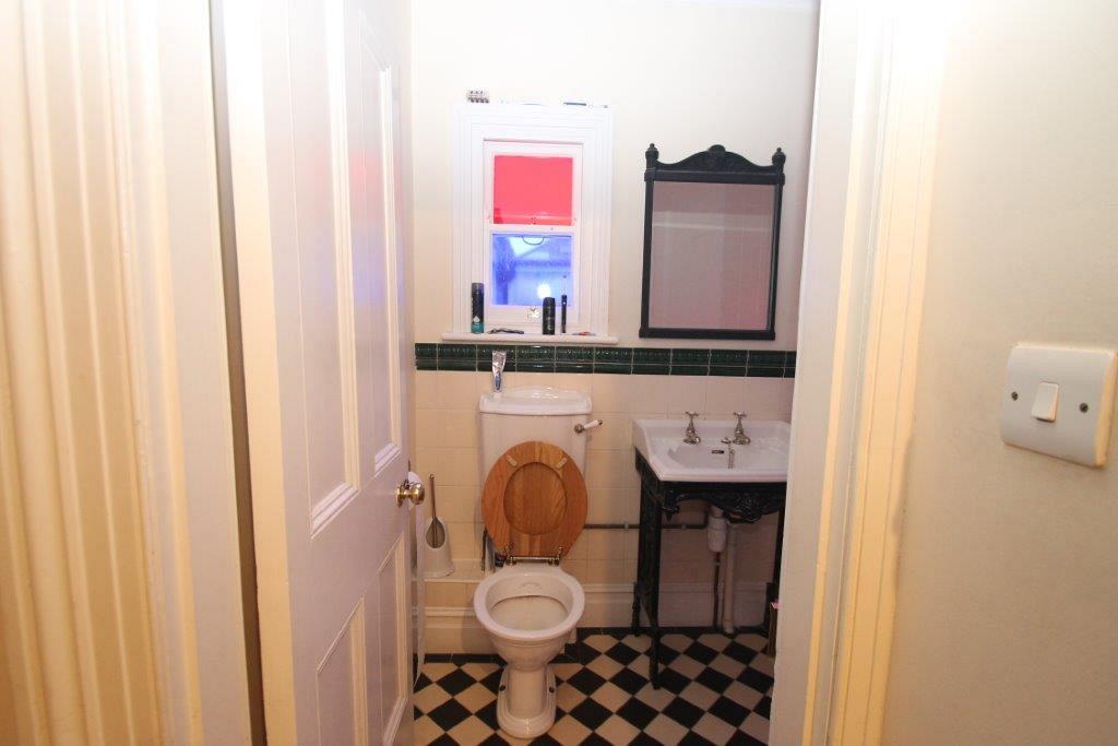 Shared bathroom with toiler, sink and blank mirror