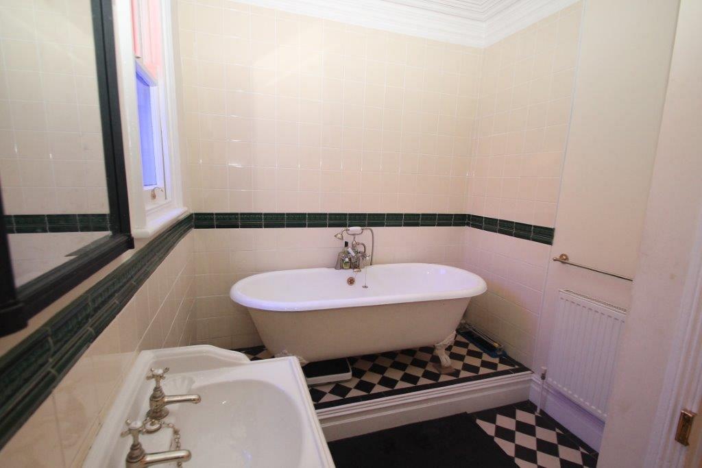 Shared bathroom with bath, black and white floor tiling