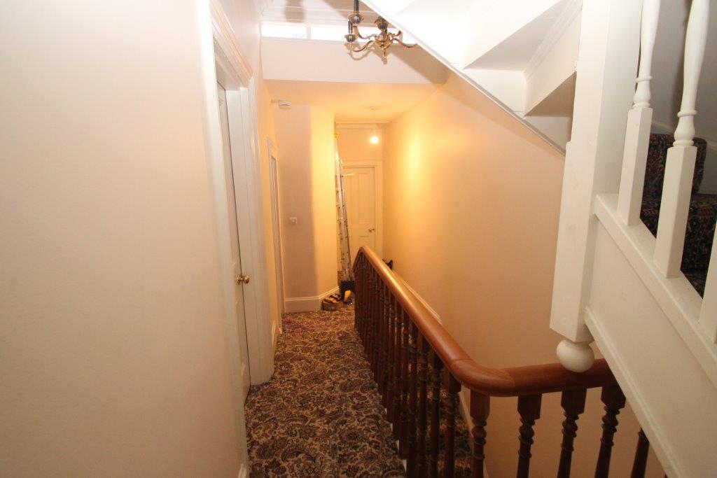 First floor landing showing entrances to rooms and another staircase going up
