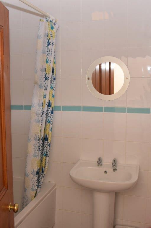 Shared bathroom with bath and shower head