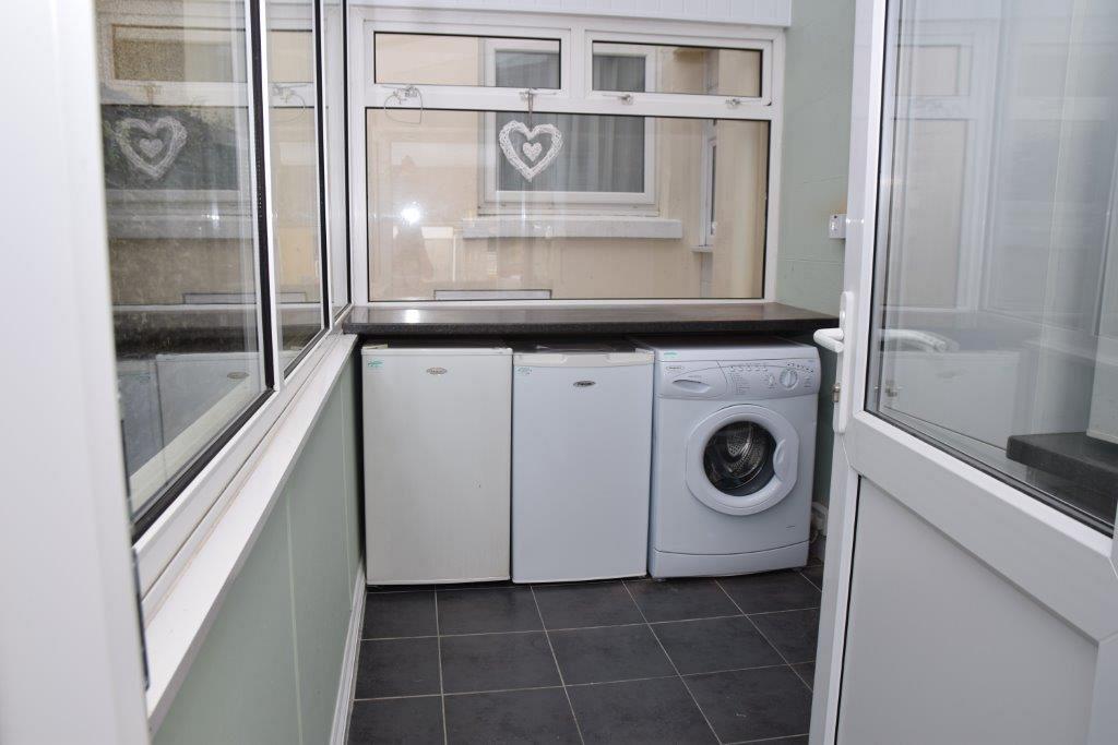 Shared utility room with small fridge, small freezer and washer/dryer