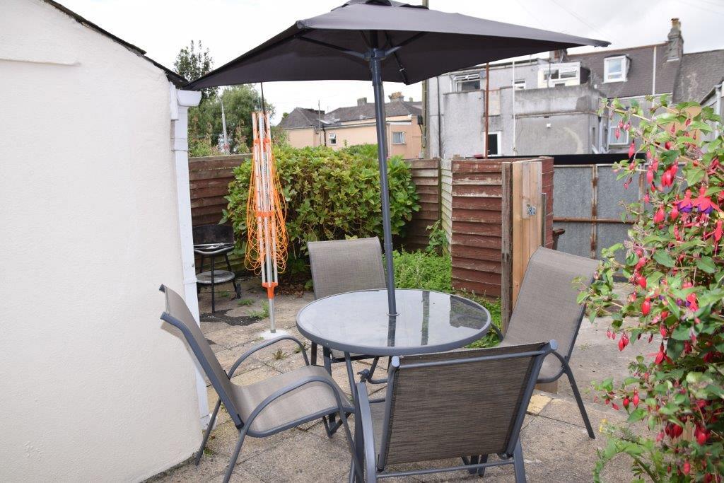Back patio with outside furniture, gate leading to off-road parking and shed