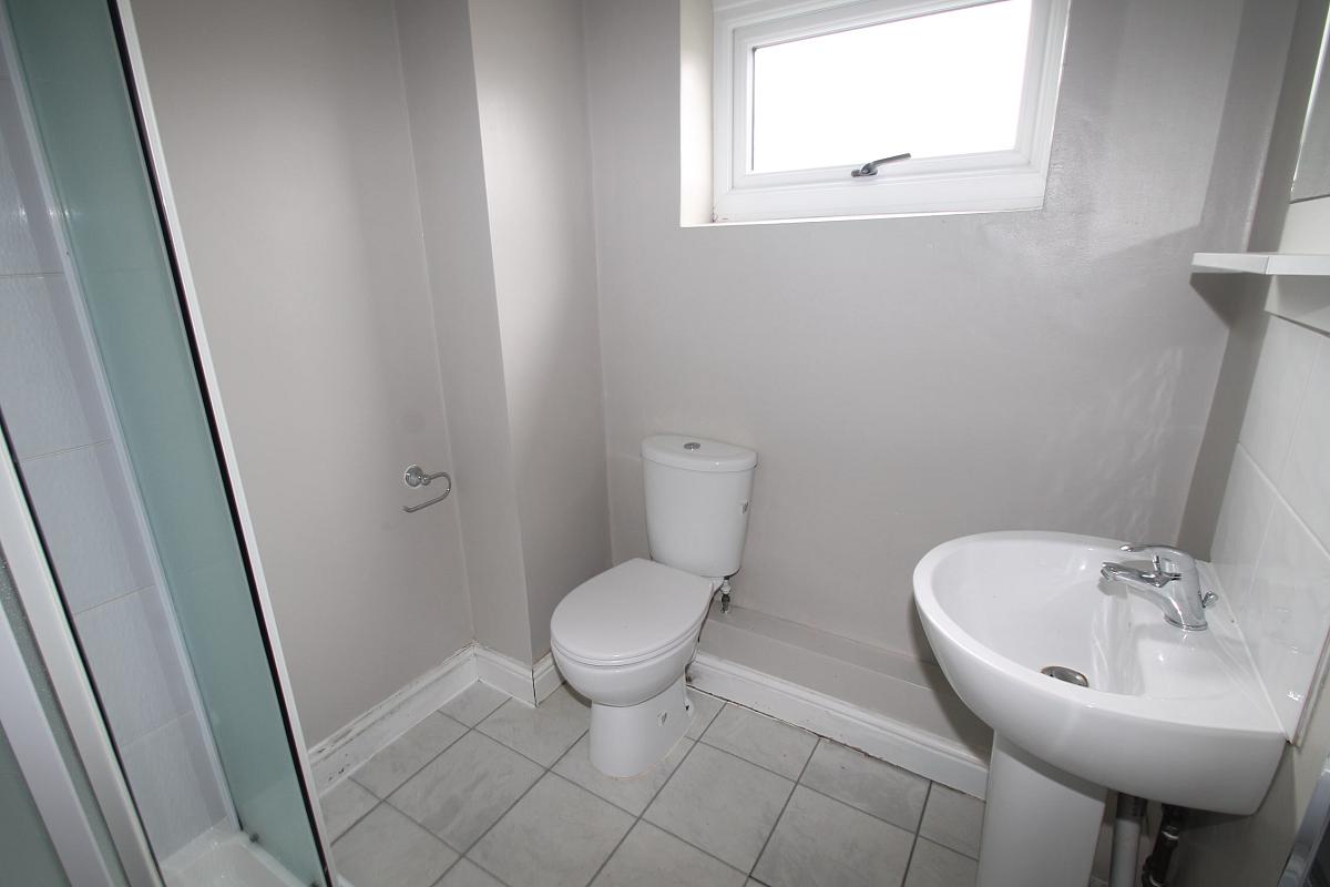 Shared bathroom with shower and mirror mounted above the sink