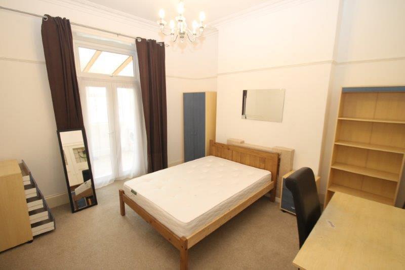 Student bedroom with double bed, desk with chair, chest of drawers, two door wardrobe, shelving unit and full length mirror