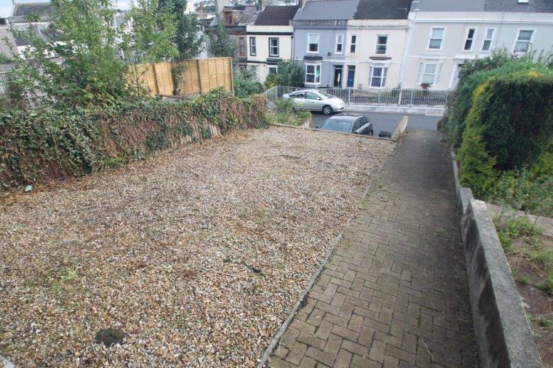 Walkway to the property, large space with stones and car parking space below