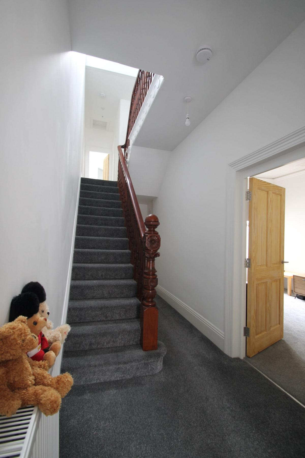 Hallway leading to shared kitchen area and stairs 