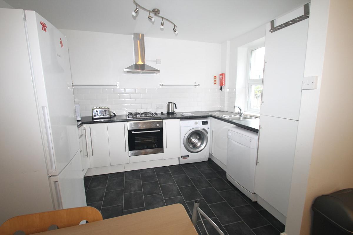 white kitchen with gas hob and cooker, fridge freezer, washing machine, dishwasher  and sink