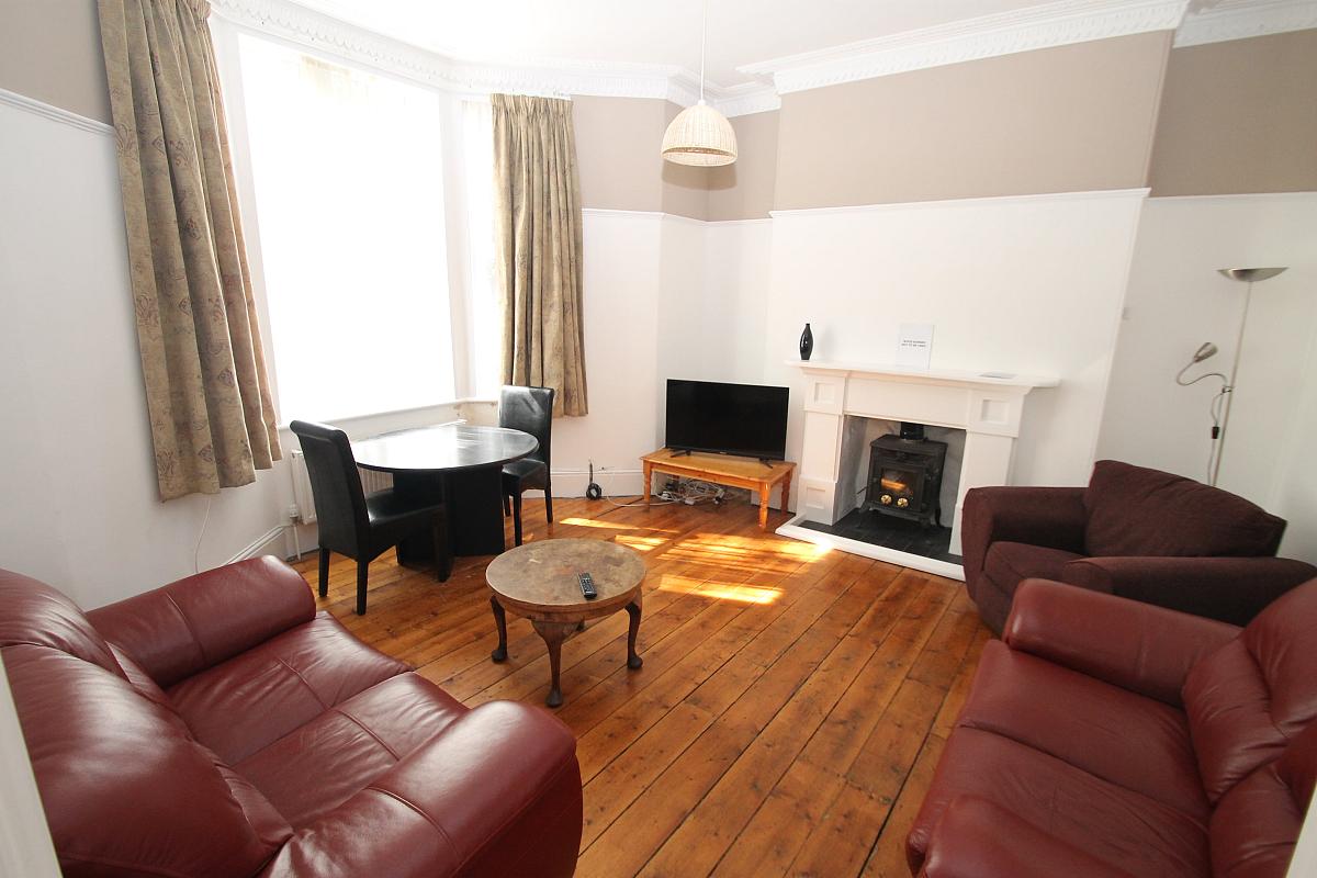 shared living room with two double sofas, arm chair and two seater dining table