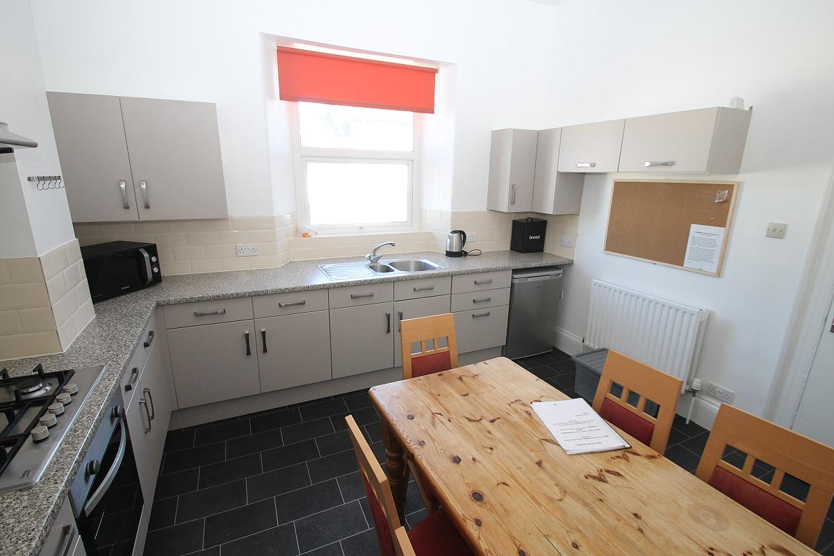 Shared kitchen with fridge freezer, small freezer, hob and cooker and dining table