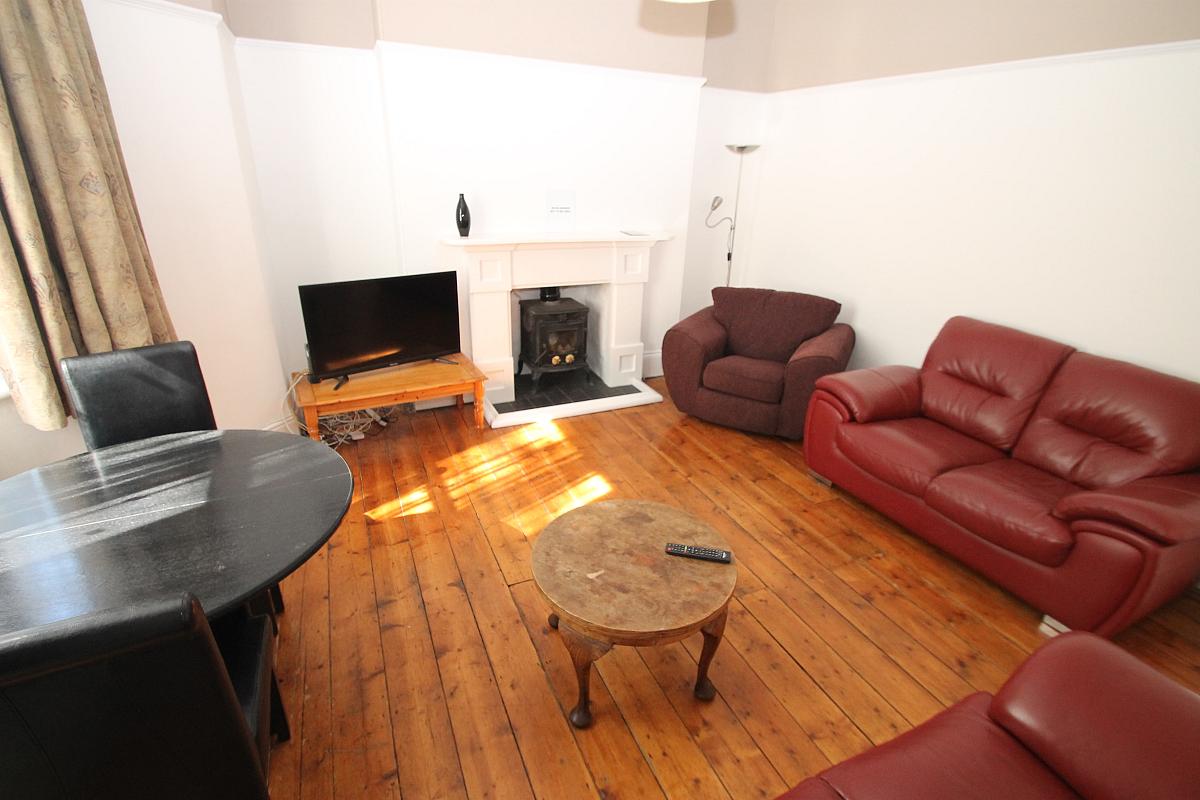 shared living room with two double sofas, arm chair and two seater dining table