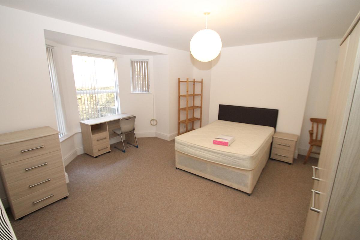 Fifth student bedroom with double bed, two door cupboard,. chest of drawers, desk and shelving unit