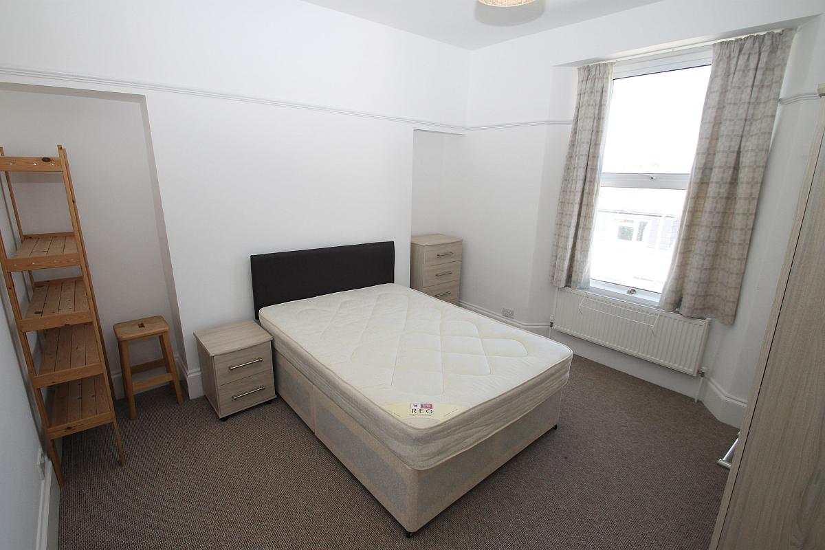 Third student bedroom with double bed, two door wardrobe, chest of drawers, bedside table and shelving unit