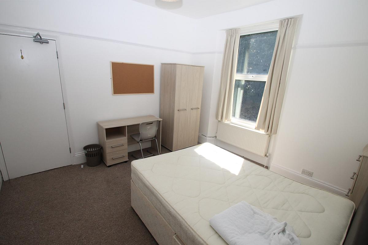 Second student bedroom with double bed, two door wardrobe, chest of drawers and desk