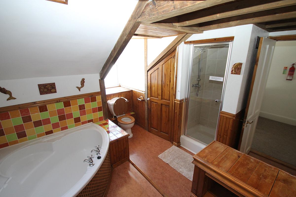 Shared bathroom with large corner bath and shower