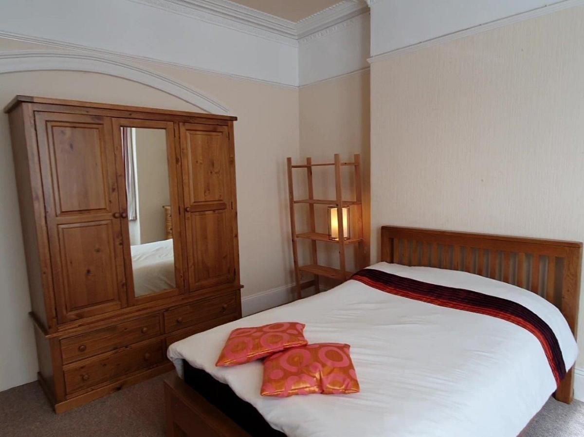 First student bedroom with double bed, large three door wardrobe with mirror and shelving unit