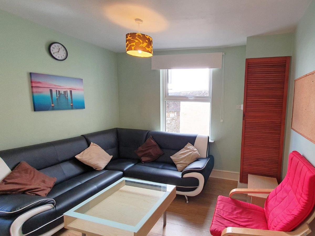 Shared living room with L shaped sofa and red single arm chair