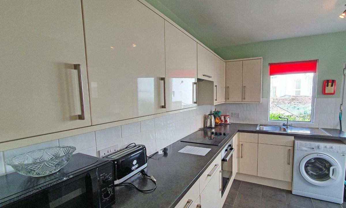 Shared kitchen with induction hob and cooker, washing machine and sink