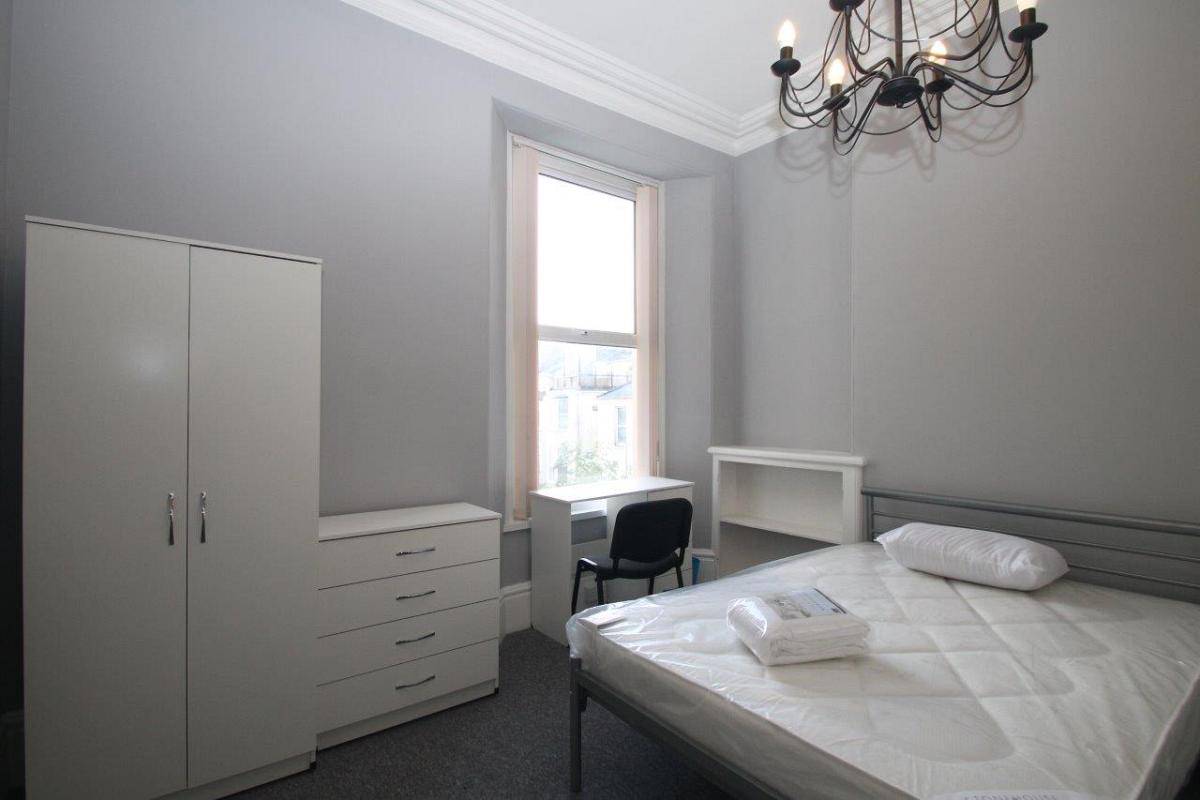 Student bedroom with double bed, chest of drawers, two door wardrobe, desk and built-in shelf space