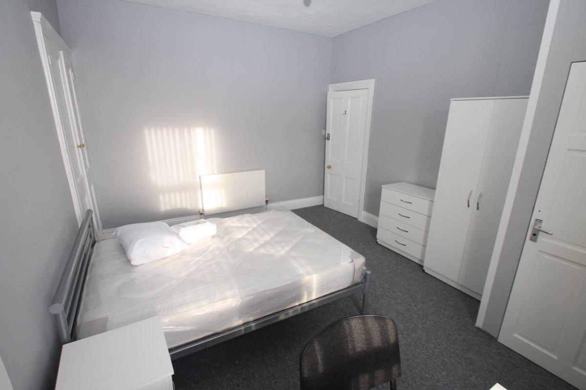 Student bedroom with double bed, chest of drawers, two door wardrobe, built-in storage space, door leading to en-suite
