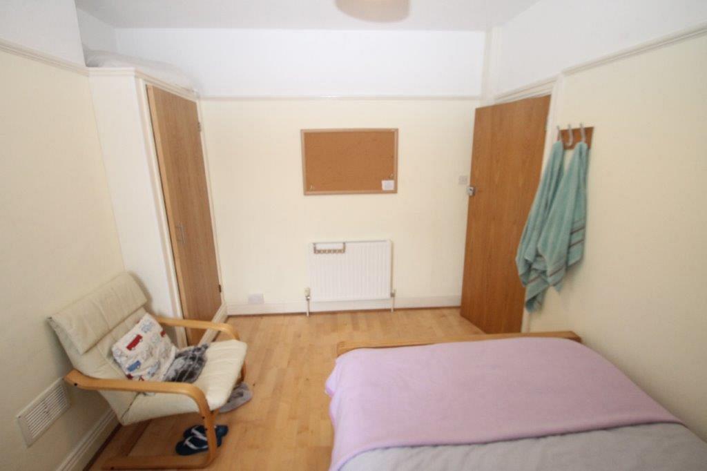 Second student bedroom with double bed, built-in wardrobe and desk