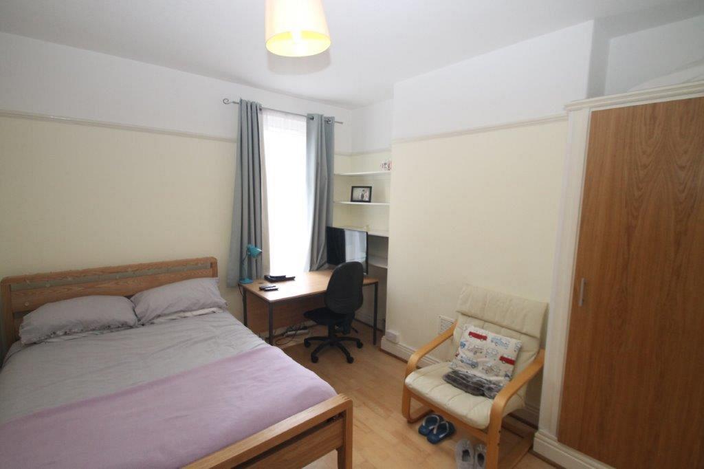 Second student bedroom with double bed, built-in wardrobe and desk